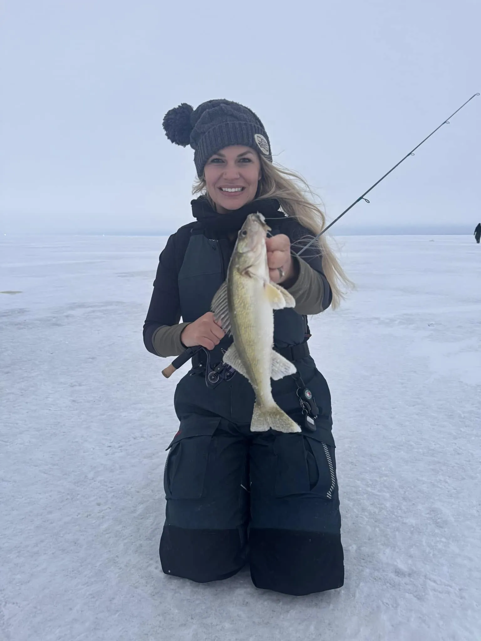 Nicole Stone ice fishing in a DSG heated vest with a walleye
