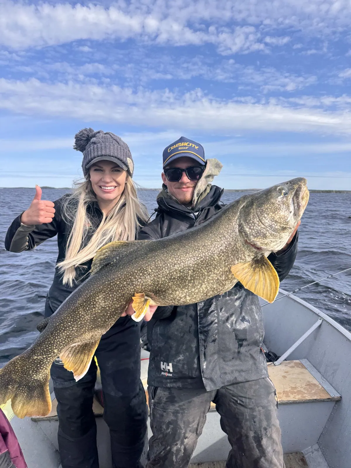 Two anglers holding up a trophy lake trout on Kamuchawie Lake